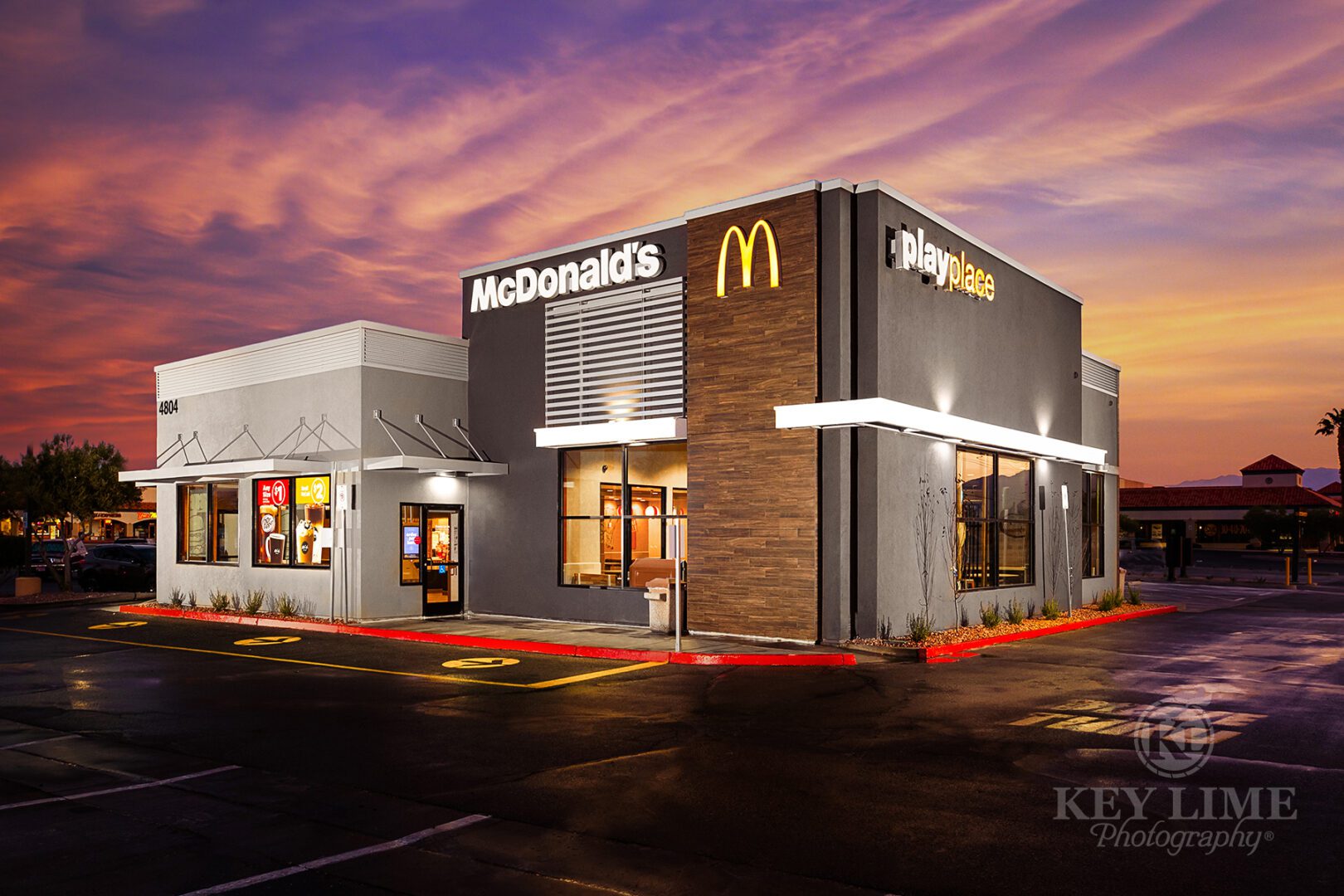 McDonalds commercial architecture photographer photo of restaurant. Warm sunrise with wet, reflective driveway.