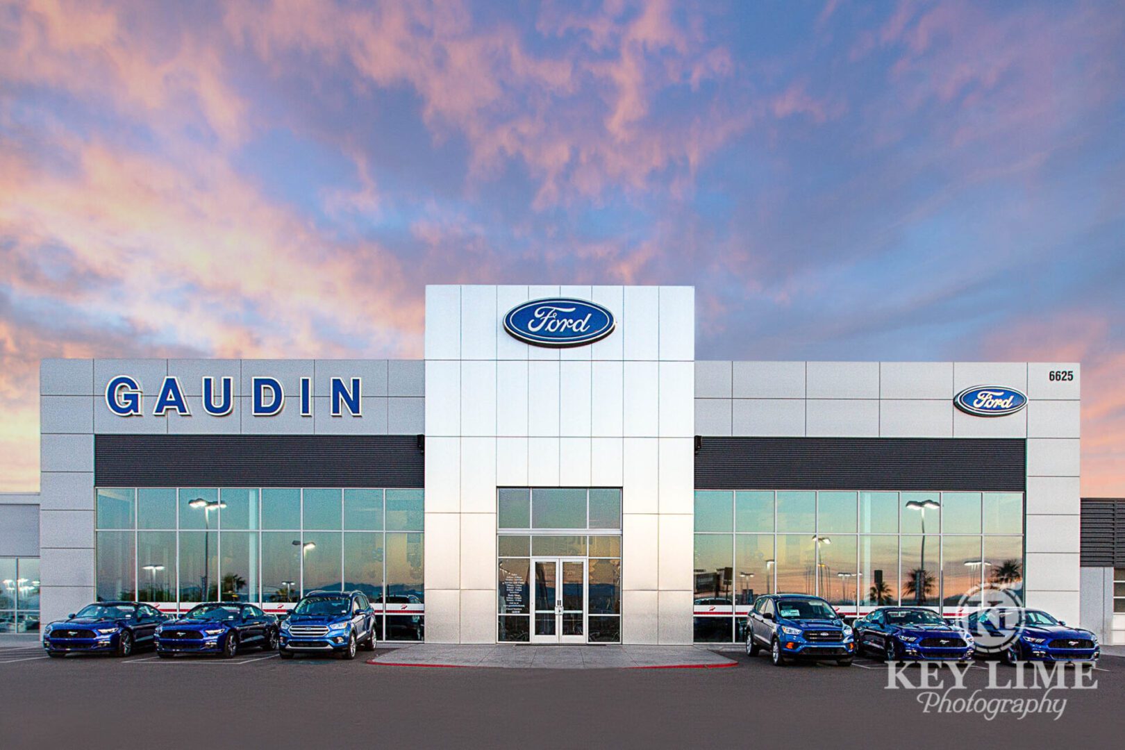 Car dealership photographer picture of storefront with pink and blue sunset.