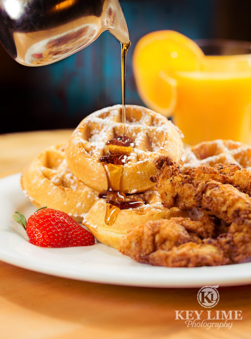 Food photographer in Las Vegas image of chicken and waffles. Strawberry and orange juice