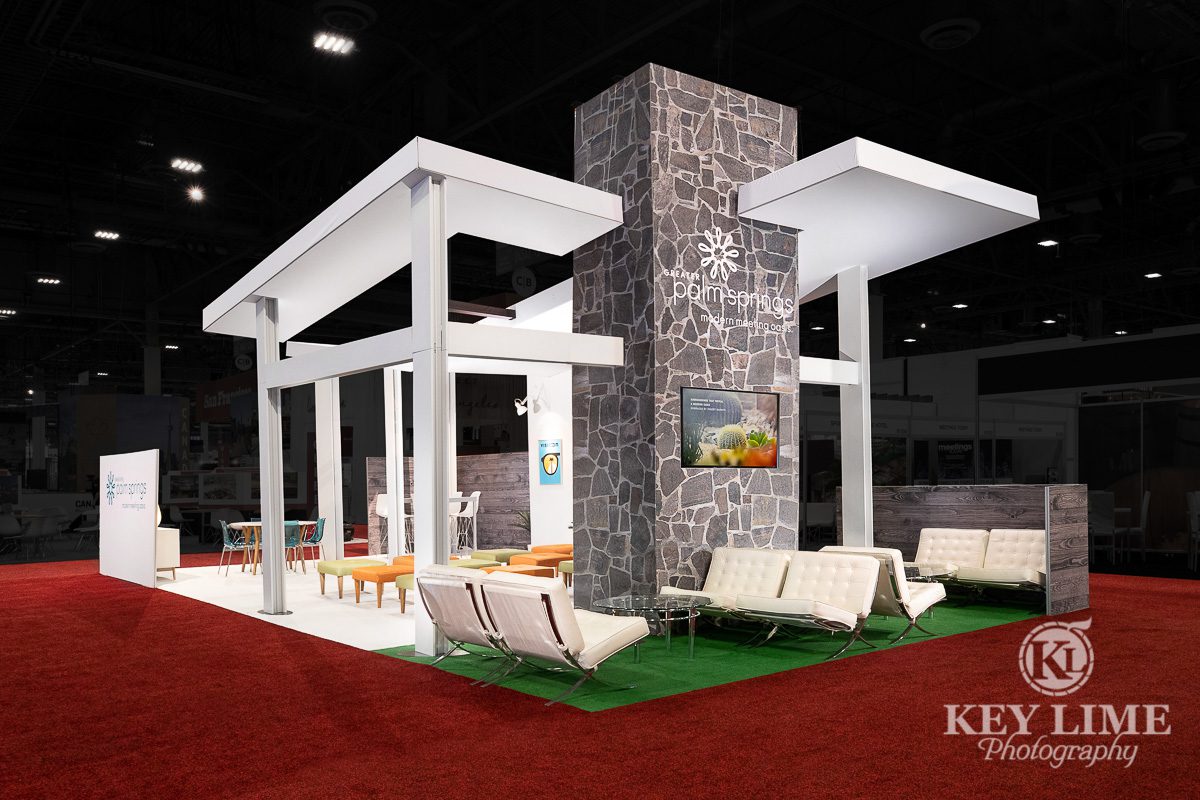 Trade show booth design, hero shot, white structure with stone accent wall. Trade show photographer Key Lime Photo