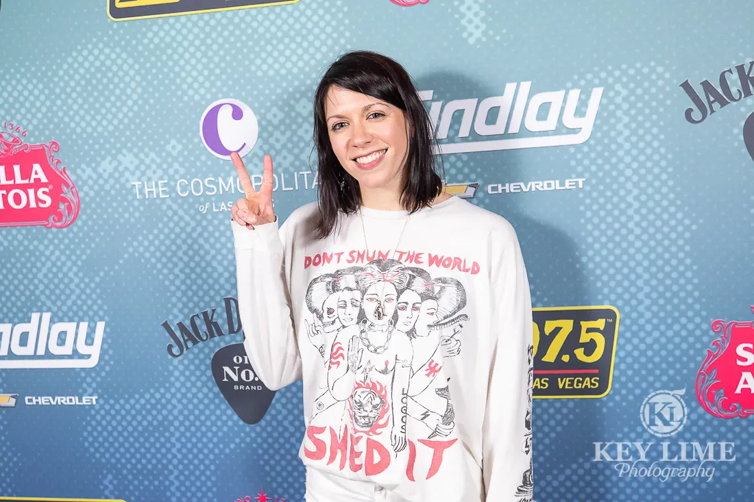K.Flay smiling with a peace sign
