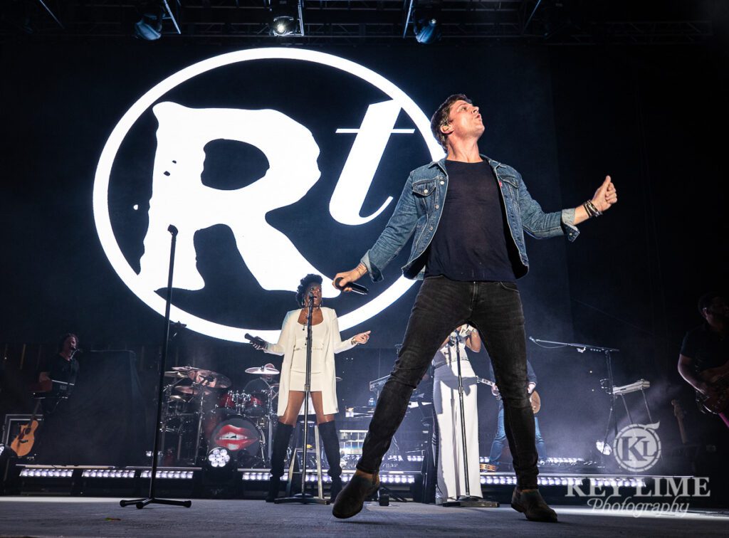 Iconic Rob Thomas photo, denim jacket and black jeans, backup singers and monochromatic stage design, giant RT logo
