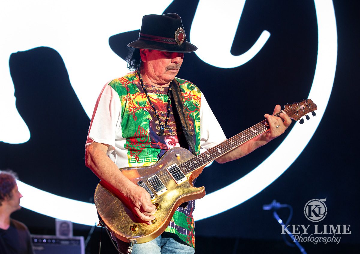 Carlos Santana with gold PRS guitar, surprise appearance at Rob Thomas concert, green and white shirt event photography