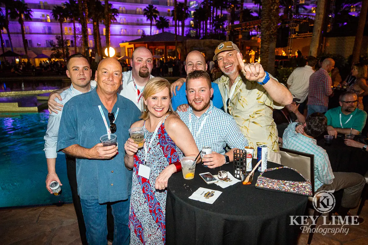 Company party near Las Vegas resort pool. Event photographer image of smiling, jovial coworkers.