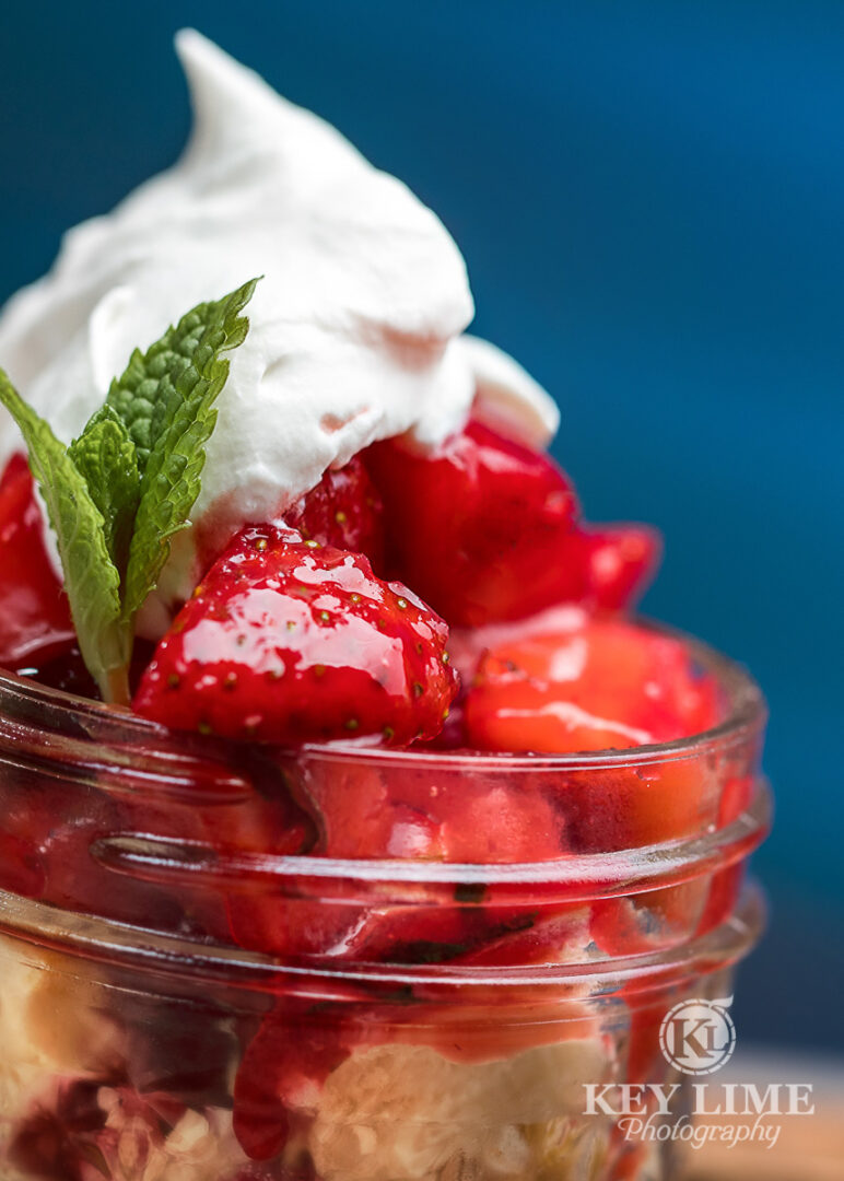 Alluring strawberry dessert photo. Whip cream and shortcake on a blue background.