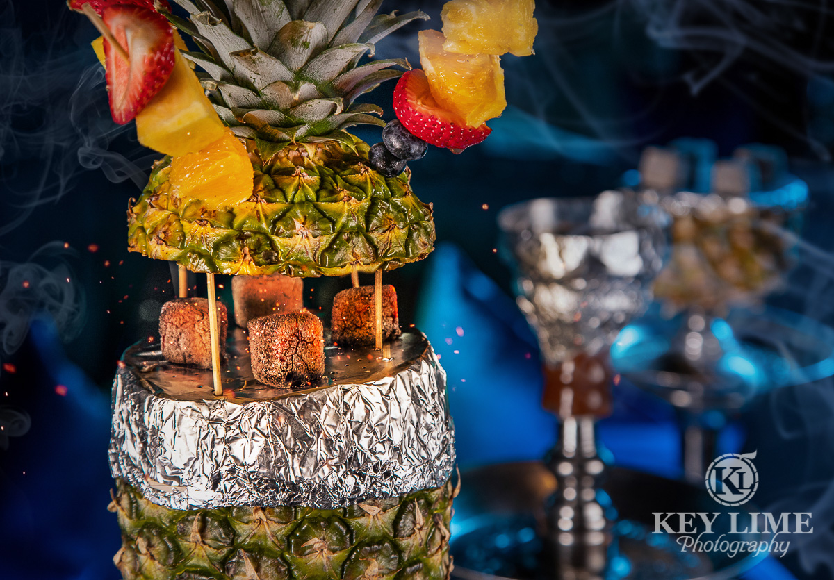 Pineapple hookah with fruit skewers. Picture uses long exposure to show coals glowing hot.