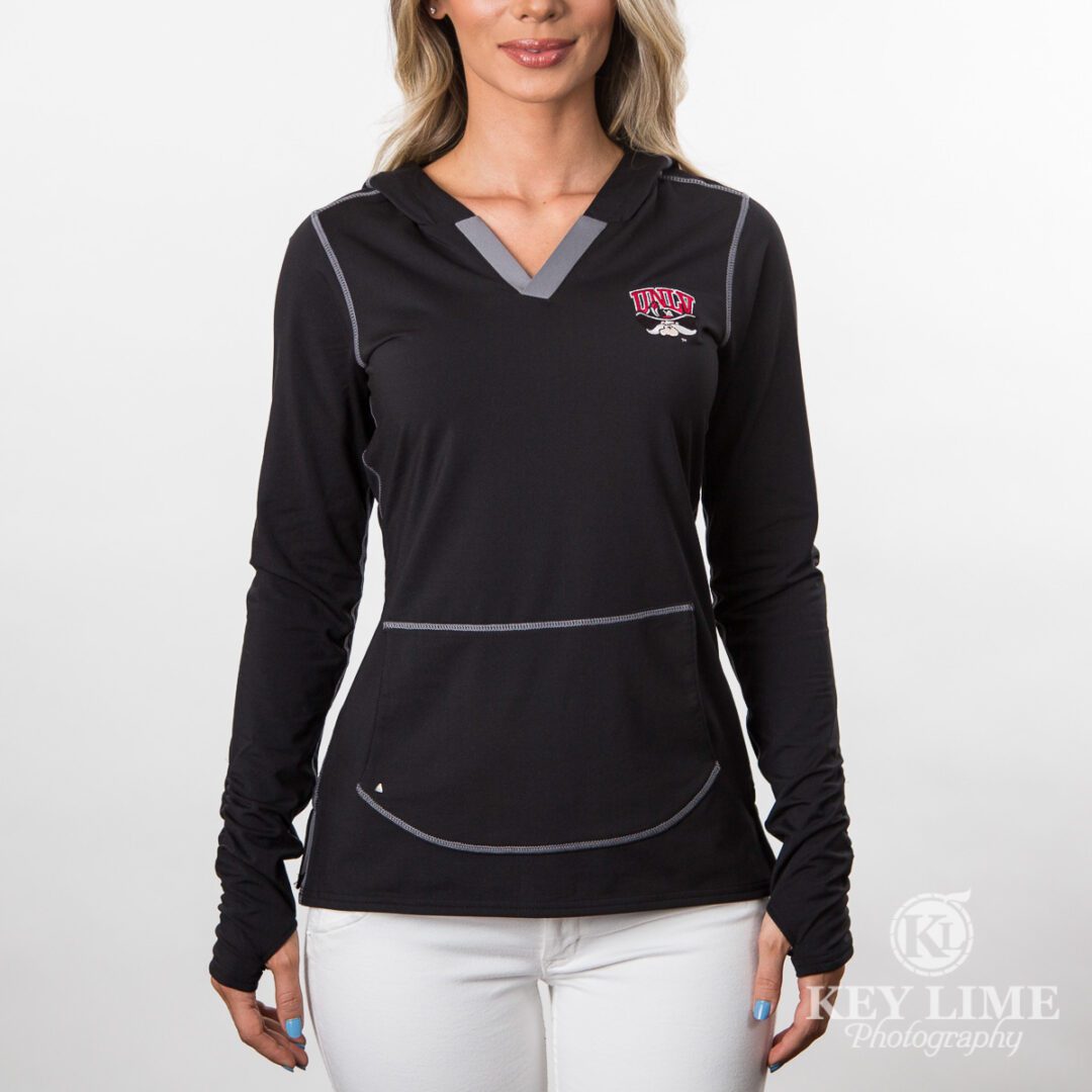 College sports product photography. Black, jacket for women. Curvy model wearing hoodie and white pants.